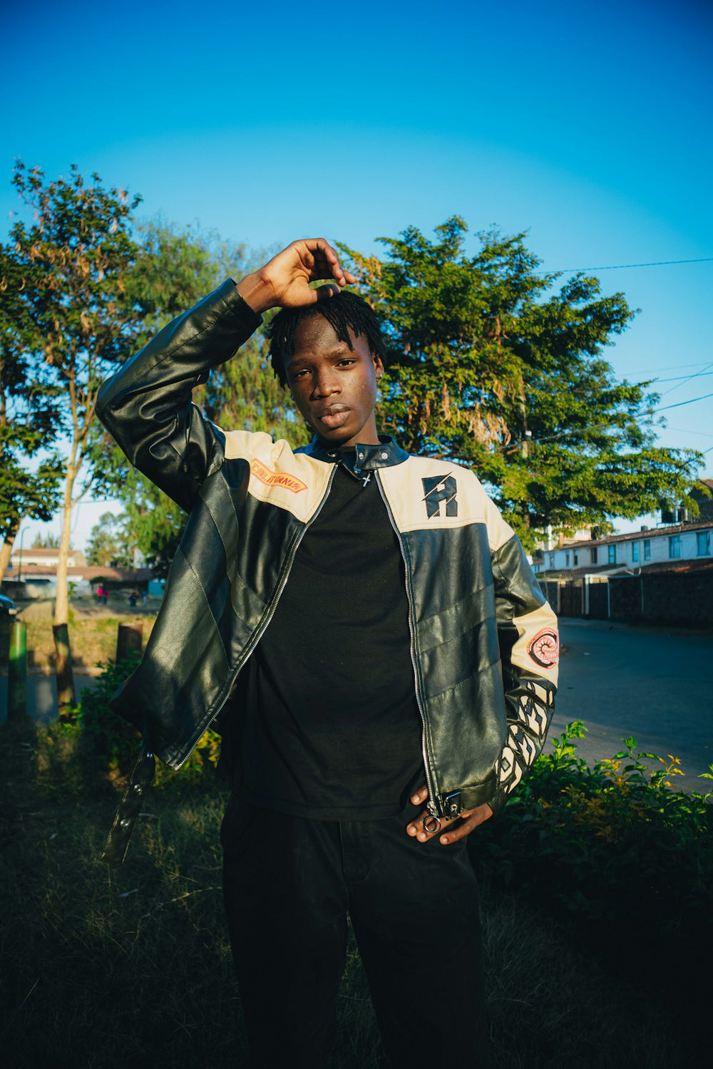 Streetwear inspiration: a young man wearing a black leather jacket outdoors. Photo by Michael Kyule.